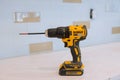 Modern cordless screwdriver, DeWalt drill with drill a wooden floor of new house for the construction