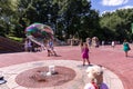 People at a square at Bethesda fountain create gigantic soap bubbles