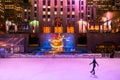 New York Rockefeller center ice skate rink with colorful lighting and people are skating.