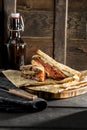 New York sandwich with pastrami, sauce 1000 islands and sauerkraut and beer bottle on wooden background Royalty Free Stock Photo