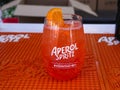 Popular Aperol Spritz cocktail in a glass with ice and orange on the bar table top