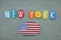 New York, souvenir composed with hand painted multi colored stone letters and a USA flag over green sand Royalty Free Stock Photo