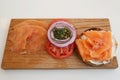 New York Style Bagel with smoked salmon on wooden board with cream cheese, tomato, onion and capers Royalty Free Stock Photo