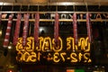 Pastrami hanging from ceiling in front of neon writing