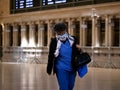 New York, United States, USA March 26, 2020: tired nurse walking through closed, empty grand central station during