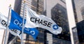 Flags of Chase Bank waving in the wind in a financial district