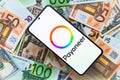 smartphone screen with digital payment service Payoneer mobile application on US dollar and euro banknotes background