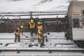 Workers clearing frozen snow from railroad track in Manhattan USA.