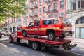 FDNY vehicle being transported on a tow truck on a street of Manhattan.