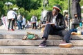 NEW YORK, USA - JUNE 3, 2018: Afro american man sitting in the park drawing. Manhattan street scene. Union square park. Royalty Free Stock Photo