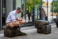 New York, USA - June 6, 2019: On the sidewalk, a man sits on a bench and reads a book - image