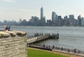 New York, USA - June 09, 2018: Tourists near the Statue of Liberty and the Lower Manhattan skyscrapers at the background. Royalty Free Stock Photo