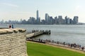 New York, USA - June 09, 2018: Tourists near the Statue of Liberty and the Lower Manhattan skyscrapers at the background. Royalty Free Stock Photo