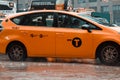 New York, USA - June 16, 2017: Yellow taxi cab speeds through busy traffic of downtown New York City on a rainy day.