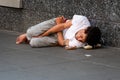 New York, USA - June 23, 2019: A young man is lying on a pedestrian sidewalk in Manhattan - image