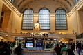 Interior of Main Concourse of Grand Central Terminal with the Clock and people walking around. Beautiful windows in the background