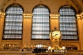 Interior of Main Concourse of Grand Central Terminal with Clock and people walking around. Beautiful windows behind. Closeup