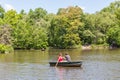 New York, USA- May 20, 2014. A couple rowing the rowboat in lake