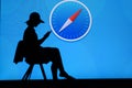 NEW YORK, USA, 25. MAY 2020: Safari graphical web browser developed by Apple Young woman silhouette sitting on chair and playing