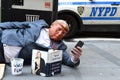 New York, USA - May 30, 2018: Street beggar wears a Trump mask a