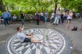 Visitor taking photos with the Imagine memorial mosaic in Central Park