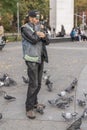 New York, USA - November 3, 2018: Man holding and feeding pigeon birds at SoHo, New York Royalty Free Stock Photo