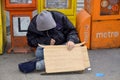 A homeless man sleeping beside newpaper boxes