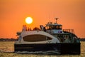 New York, New York, USA 08 20 2017 Relaxing people on ferry to Wall Street from Rockaway with orange dusk behind