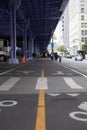 Middle of city road yellow line with purple cieling overhead bridge