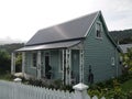 New Zealand: Akaroa historic 19th century grey cottage with verandah