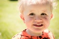 A young boy smile into the camera with soft background