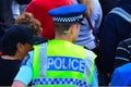 New Zealand police officer walks in a crowed of people