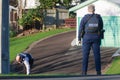 New Zealand police. A policewoman watches while a colleague searches