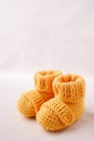 Newborn announcement. knitted baby booties on light white background.