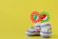 Newborn announcement. knitted baby booties on plain yellow background