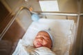 Newborn asleep in hospital bed with eyes closed