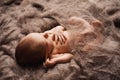 Newborn baby asleep on a grey wool blanket at a newborn photoshoot