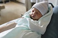 Newborn baby asleep, swaddled in hospital blanket and wearing a hat Royalty Free Stock Photo