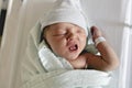 Newborn baby asleep, swaddled in hospital blanket and wearing a hat Royalty Free Stock Photo