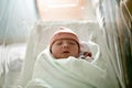 Newborn baby asleep, swaddled in hospital blanket and wearing a hat Royalty Free Stock Photo