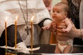 Newborn baby baptism in Holy water. baby holding mother`s hands. Infant bathe in water. Baptism in the font Royalty Free Stock Photo