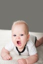 Newborn baby on the bed yawns close-up and copy space. Funny baby bedtime in the bedroom. Royalty Free Stock Photo