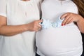 Newborn baby booties in parents hands. Pregnant woman belly. Royalty Free Stock Photo