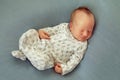 Newborn baby boy asleep on a blue background in white pajamas wi Royalty Free Stock Photo