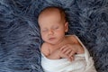 Newborn baby boy in bed. New born child sleeping under a white knitted blanket. Children sleep. Royalty Free Stock Photo
