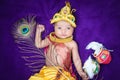 newborn baby boy in krishna dressed with props from unique perspective in different expression