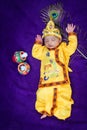 newborn baby boy in krishna dressed with props from unique perspective in different expression