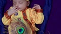 newborn baby boy in krishna dressed with props from unique perspective in different expression