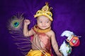 newborn baby boy in krishna dressed with props from unique perspective in different expression