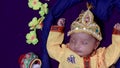 newborn baby boy in krishna dressed with props from unique perspective in different expression